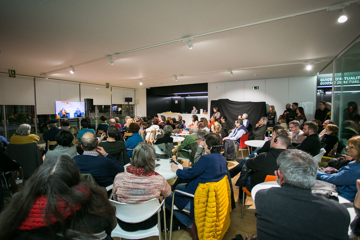 El públic seguint la conversa entre Erri de Luca i David Fernàndez, des d'una de les sales annexes habilitades. Foto: Martí Albesa.