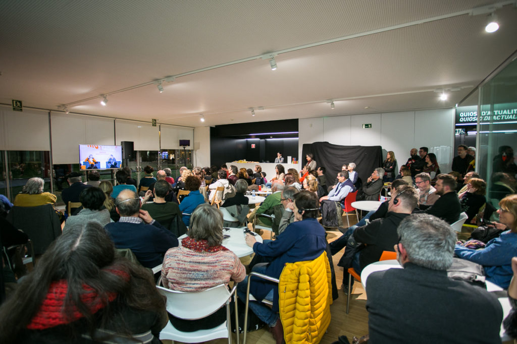 El públic seguint la conversa entre Erri de Luca i David Fernàndez, des d'una de les sales annexes habilitades. Foto: Martí Albesa.